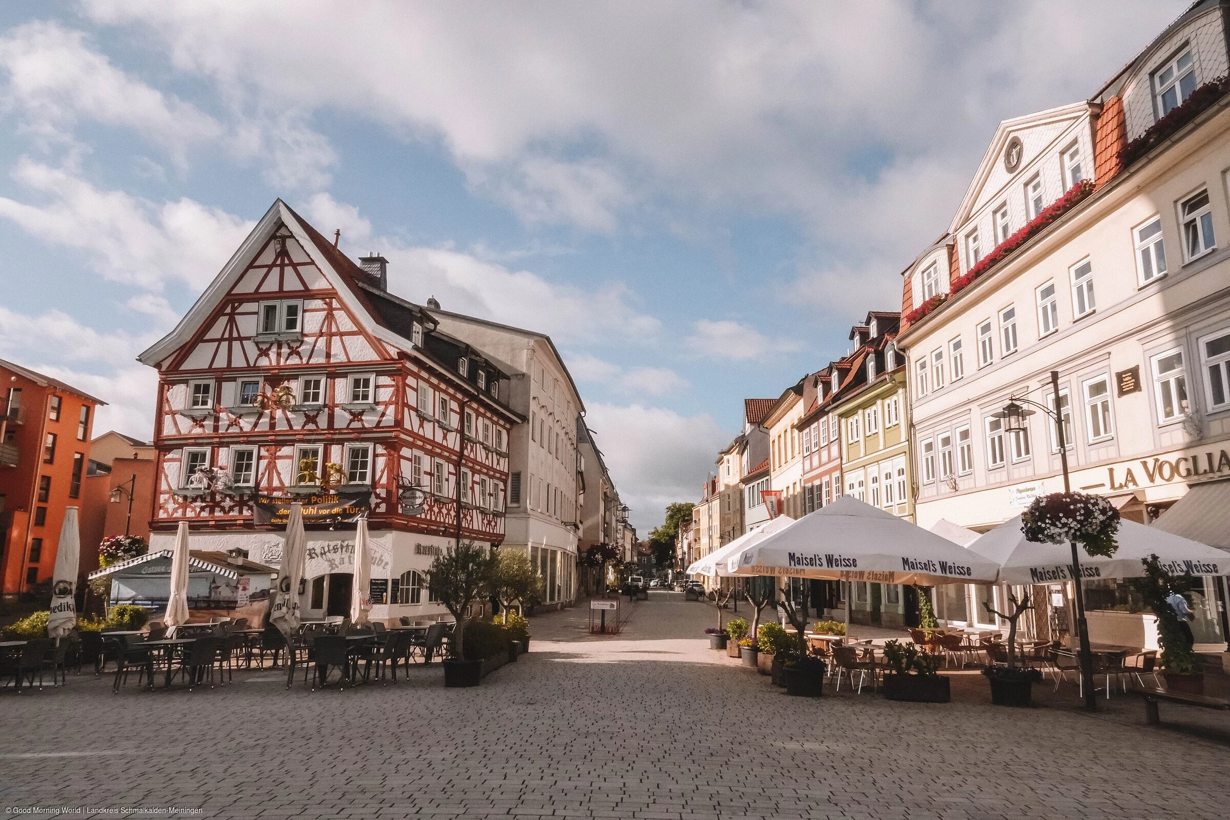 Blick hinein in eine Straße mit Fachwerkäusern und Gastronomie