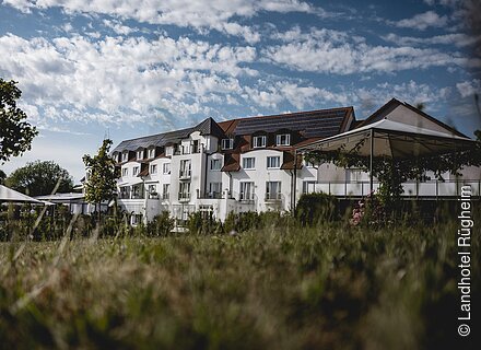 Ein großes, weißes Hotel mit Garten davor